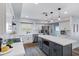 Well-lit kitchen with a gray island, white quartz countertops, stainless appliances, and wood-look tile flooring at 8556 E Pecos Ln, Scottsdale, AZ 85250