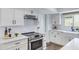 A well-designed kitchen featuring white cabinets, quartz countertops, stainless steel appliances, and stylish tile backsplash at 8556 E Pecos Ln, Scottsdale, AZ 85250