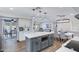 Kitchen with a gray island, quartz countertops, stainless steel appliances, and a view into the living room at 8556 E Pecos Ln, Scottsdale, AZ 85250