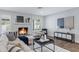 Cozy living room showcases a decorative fireplace, neutral decor, and warm wood-look tile flooring at 8556 E Pecos Ln, Scottsdale, AZ 85250