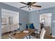 Home office featuring a ceiling fan, natural light, view to the living room and wood-look flooring at 8556 E Pecos Ln, Scottsdale, AZ 85250