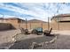 Cozy backyard featuring a fire pit, gravel, and stylish wicker patio furniture, perfect for outdoor entertaining at 868 W Desert Glen Dr, San Tan Valley, AZ 85143