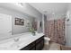 A serene bathroom showcases an extended vanity and a shower with patterned curtains at 868 W Desert Glen Dr, San Tan Valley, AZ 85143