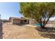 View of the backyard with a mature shade tree and a fenced swimming pool at 8816 W Catalina Dr, Phoenix, AZ 85037