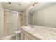 Bright bathroom with a glass-enclosed shower and marble countertops at 8816 W Catalina Dr, Phoenix, AZ 85037