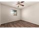 Bright bedroom with dark floors and a nice view out the window at 8816 W Catalina Dr, Phoenix, AZ 85037