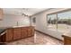 Kitchen area featuring tile floors, wood cabinets, modern sink, and window for natural light at 8816 W Catalina Dr, Phoenix, AZ 85037