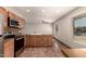 Kitchen area with tile floors, wood cabinets, and stainless-steel appliances at 8816 W Catalina Dr, Phoenix, AZ 85037