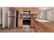 Kitchen view of stainless-steel appliances, wood cabinets, and tile floors at 8816 W Catalina Dr, Phoenix, AZ 85037