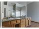 Bathroom with double sinks, granite countertop, wood cabinets, and large mirror at 934 E Carlise Rd, Phoenix, AZ 85086