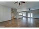 Large living room with wood flooring, ceiling fan, and view into the kitchen and outdoor area at 934 E Carlise Rd, Phoenix, AZ 85086