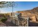 An outdoor kitchen featuring a built-in grill and counter space amidst a gravel-covered yard at 10328 W Villa Linda Dr, Peoria, AZ 85383