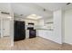 Well-lit kitchen with white cabinets, black appliances, and tile floors for easy maintenance at 10533 W Lawrence Ln, Peoria, AZ 85345