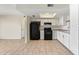 Efficient kitchen boasts white cabinetry, sleek black appliances, and ample countertop space at 10533 W Lawrence Ln, Peoria, AZ 85345