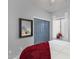 Cozy bedroom featuring a window with curtains, closet doors, mirror, and bed with red blanket at 10905 E Peralta Canyon Dr, Gold Canyon, AZ 85118