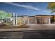 Well-maintained single-story home featuring a three-car garage, desert plants, and illuminated entry at night at 10951 E Mirasol Cir, Scottsdale, AZ 85255