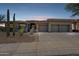 Charming single-story home boasting a three-car garage, desert landscaping, and a welcoming facade at twilight at 10951 E Mirasol Cir, Scottsdale, AZ 85255