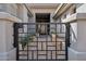Wrought iron gate leading to the front door with desert landscaping, pots, and pavers at 10951 E Mirasol Cir, Scottsdale, AZ 85255