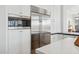 Modern kitchen featuring stainless steel refrigerator, oven, and white cabinets at 10951 E Mirasol Cir, Scottsdale, AZ 85255
