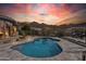 Inviting pool area with desert landscaping, mountain views, and colorful sky at sunset at 10951 E Mirasol Cir, Scottsdale, AZ 85255