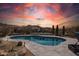 Inviting pool area with desert landscaping, mountain views, and colorful sky at sunset at 10951 E Mirasol Cir, Scottsdale, AZ 85255