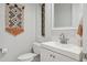 This powder room features a modern faucet, square mirror, geometric wall hanging and toilet at 10951 E Mirasol Cir, Scottsdale, AZ 85255