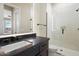 Modern bathroom with white backsplash, dark countertop and cabinetry, and glass shower enclosure at 12315 E Black Rock Rd, Scottsdale, AZ 85255
