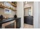 An inviting bar area offers sleek black counters, floating shelves, and an under-counter drink refrigerator at 12315 E Black Rock Rd, Scottsdale, AZ 85255