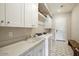 Well-organized laundry room with white cabinets, marble countertop, sink, and modern appliances at 12315 E Black Rock Rd, Scottsdale, AZ 85255