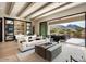 Bright living room featuring wood beam ceiling, modern furnishings, and seamless indoor/outdoor flow to a patio with mountain views at 12315 E Black Rock Rd, Scottsdale, AZ 85255