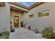 Charming courtyard entrance with decorative potted plants, desert landscaping, and a decorative front door at 12770 N 145Th Way, Scottsdale, AZ 85259