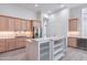 Bright kitchen with a white central island, stainless steel fridge and light wood cabinets at 12770 N 145Th Way, Scottsdale, AZ 85259