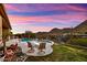 Backyard oasis featuring a pristine pool, lush landscaping, mountain views and sunset skies, perfect for relaxing at 12770 N 145Th Way, Scottsdale, AZ 85259