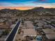 Sunset aerial view of a residential area featuring homes with pools, spas, and mountain views at 1319 N Chatsworth St, Mesa, AZ 85207