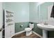 Cozy bathroom featuring a pedestal sink, toilet, and charming decorative elements with soft green and white tones at 1319 N Chatsworth St, Mesa, AZ 85207