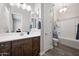 Bathroom featuring a dark wood vanity, double sinks, and a shower-tub combination at 1319 N Chatsworth St, Mesa, AZ 85207