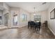 A dining area with wood tile floors, a black table with chairs, and modern light fixtures at 1319 N Chatsworth St, Mesa, AZ 85207