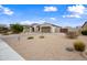 Charming home featuring a brick driveway, three-car garage, and desert landscaping under a blue sky at 1319 N Chatsworth St, Mesa, AZ 85207