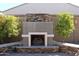 Outdoor stone fireplace and seating area is surrounded by lush landscaping to make for a relaxing outdoor escape at 1319 N Chatsworth St, Mesa, AZ 85207