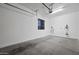Clean, white garage with painted concrete flooring, natural light, and organization system and installed vacuum at 1319 N Chatsworth St, Mesa, AZ 85207