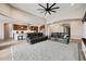 A living room featuring a gray rug, leather couches, a ceiling fan and open access to the kitchen at 1319 N Chatsworth St, Mesa, AZ 85207