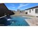 A backyard with a pool and waterfall feature, along with grassy areas and privacy landscaping at 1319 N Chatsworth St, Mesa, AZ 85207