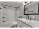 Modern bathroom featuring white vanity, granite countertops, black hardware, and a bathtub with shower at 1340 N Recker Rd # 118, Mesa, AZ 85205