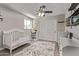 Inviting bedroom with ceiling fan, crib, changing table, closet, and large window bringing in plenty of light at 1340 N Recker Rd # 118, Mesa, AZ 85205