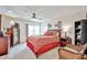 Comfortable bedroom with a ceiling fan, a sliding glass door, neutral carpet, and ample natural light at 13410 N Cedar Dr, Sun City, AZ 85351