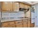 Close-up reveals the kitchen's wooden cabinets, sleek backsplash, modern cooktop, and built-in oven at 13410 N Cedar Dr, Sun City, AZ 85351
