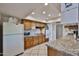 Efficient kitchen features wooden cabinetry, modern appliances, and granite countertops for cooking ease at 13410 N Cedar Dr, Sun City, AZ 85351