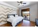Comfortable bedroom featuring stylish accent wall, ceiling fan, and sliding glass doors to the outside at 14426 N Vista Del Oro --, Scottsdale, AZ 85264