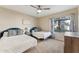 Bright bedroom with two twin beds, ceiling fan, and large window with floral curtains at 15095 N Thompson Peak Pkwy # 1053, Scottsdale, AZ 85260