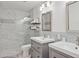 Bathroom featuring dual sinks, sleek mirrors, and a glass enclosed shower at 16014 S 13Th Way, Phoenix, AZ 85048